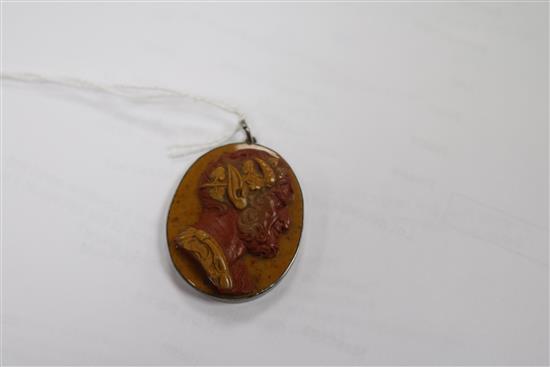 A 19th century red and yellow layered hardstone cameo carved with the head of a satyr, in pendant mount, 38mm.